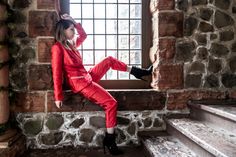 a woman in red is sitting on the window sill