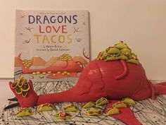 there is a book about love tacos next to a red dragon