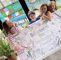 three children holding up a large sign with writing on it