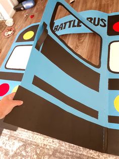 a person is holding up a cut out of a bus with the word battle bus on it