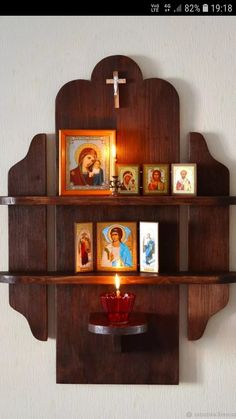 a wooden shelf with pictures and candles on it