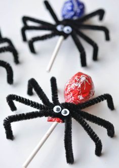 three spider lollipops are sitting on a white surface and one is made out of candy