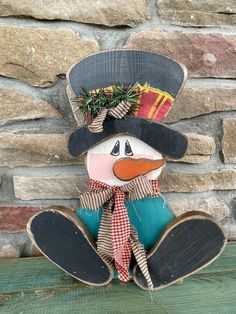 a wooden snowman with a hat and scarf