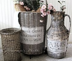 three wicker baskets with flowers in them on the floor next to a basket and vase