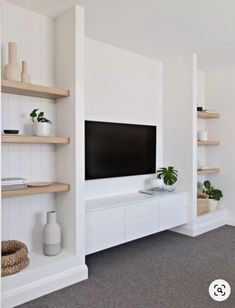 a living room with shelves and a flat screen tv