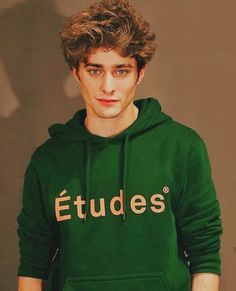 a young man wearing a green sweatshirt with the word etudes on it