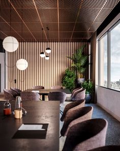 an empty meeting room with many chairs and plants in the corner, along with large windows