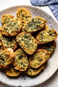 a white plate topped with mini breads covered in pesto