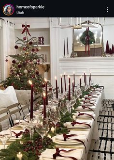 a christmas table setting with candles, plates and napkins