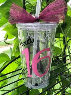 a clear cup with a purple bow on it and the number fifteen is decorated with pink ribbon