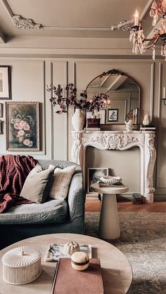 a living room filled with furniture and a fire place under a mirror on the wall