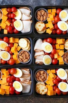 four plastic trays filled with different types of food