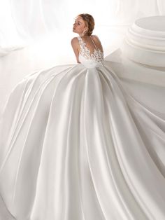 a woman in a white wedding dress is posing for the camera