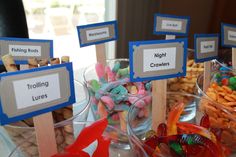 there are many different types of candies on the table with signs in front of them