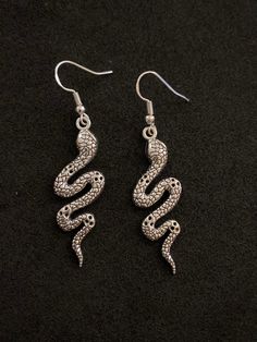 Zinc alloy silver plated snake earrings. Stirling silver earring hooks. ideal gift for a fan of snakes, fantasy, Halloween or goth style.  Comes with rubber safety backs and attached to a display card, protected by sealed plastic packaging. Thank you for looking! 🐍