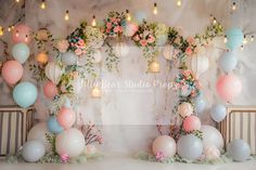 the backdrop is decorated with balloons, flowers and greenery in pastel colors for an event