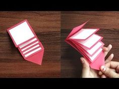 someone is folding an origami card into two sections, and it looks like they are