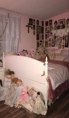 there are many stuffed animals on the floor in this bedroom with pink walls and white bedding