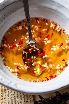 a spoon in a bowl filled with liquid and confetti sprinkles