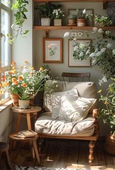 a living room filled with lots of potted plants next to a wooden table and chair