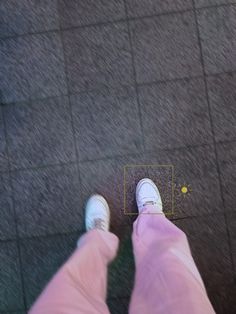 a person standing on the ground with their feet in front of a yellow square that appears to be an object