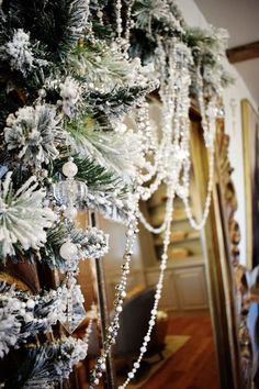 a decorated christmas tree in front of a mirror with beads and snowflakes on it