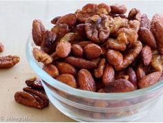 a glass bowl filled with nuts on top of a table