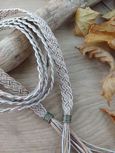 the rope is laying on the table next to some leaves and a piece of wood