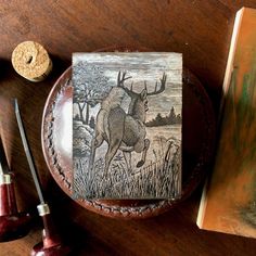 a wooden box sitting on top of a table next to a book and some other items