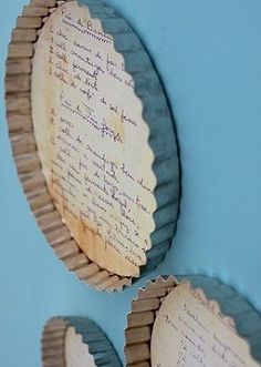 two circular mirrors with writing on them against a blue wall, one is empty and the other has been made out of paper