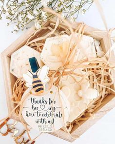 a wooden box filled with personalized tags and some flowers on top of the table