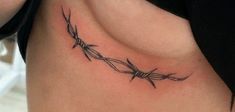 a tattoo on the side of a woman's stomach that has barbed wire attached to it