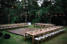 an outdoor wedding reception setup with tables and chairs set up in the middle of grass