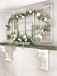 an old window is decorated with flowers and greenery