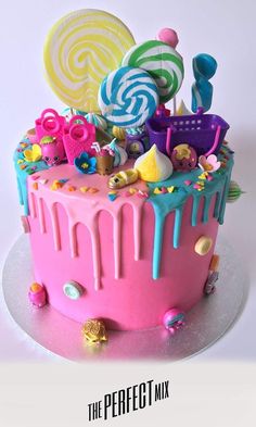 a birthday cake decorated with candy and lollipops is shown in this image