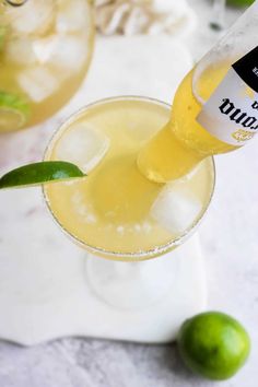 a bottle of bud sits on top of a glass filled with lemonade and lime