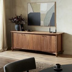 a living room with a large painting on the wall next to a table and chairs