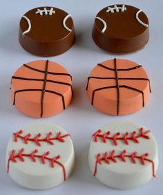 chocolates decorated with baseball, basketball and soccer ball shapes are arranged on a white surface