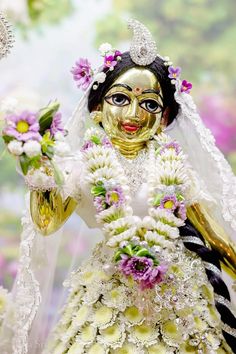 a close up of a statue of a person with flowers in her hair and makeup