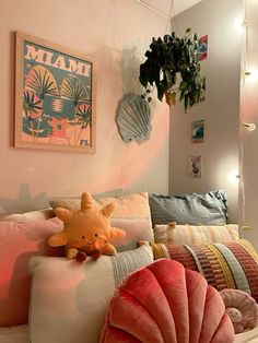 there is a stuffed animal on the pillow in this room with pink walls and pillows