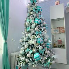 a white christmas tree with blue and silver ornaments