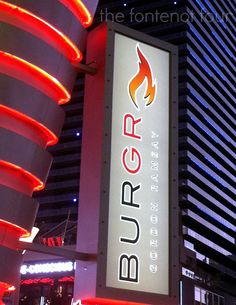 the burq sign is lit up at night in front of a tall building