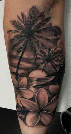 a black and white tattoo on the leg of a man with flowers in front of palm trees