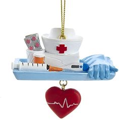 a heart shaped ornament hanging from a hook with medical supplies on it's side