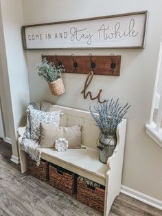 a bench with baskets and flowers on it in front of a sign that says come in and stay fishie