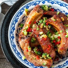 a bowl filled with meat and vegetables on top of a wooden table