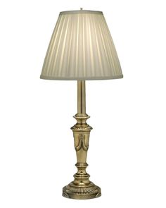 a gold lamp with a white shade on it's base and a beige lampshade