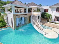 a house with a slide in the middle of it's swimming pool that is built into the ground