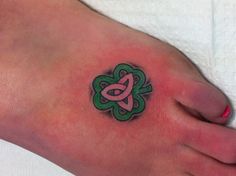 a foot with a pink and green tattoo on it