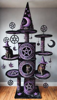 a cat is sitting in the middle of a purple tower with witches on it's sides